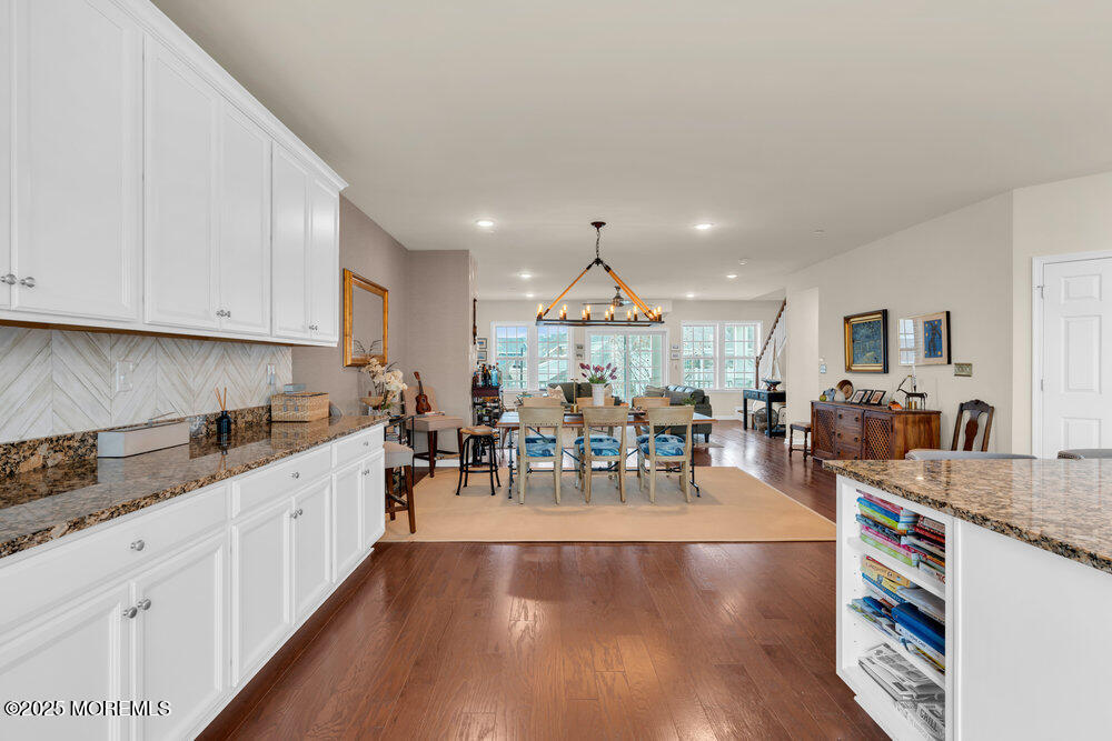 24 Lighthouse Point Road Highlands, NJ 07732 - Photo 32 of 63 a kitchen with stainless steel appliances granite countertop a stove top oven a sink a dining table and chairs with wooden floor