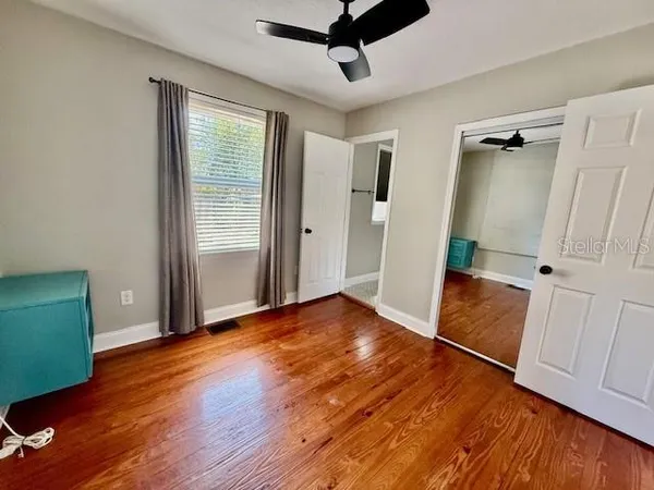 a view of empty room with wooden floor and window