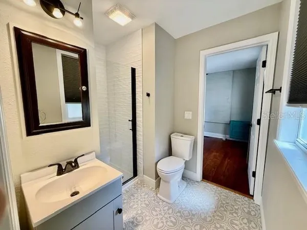 a bathroom with a sink a toilet and shower