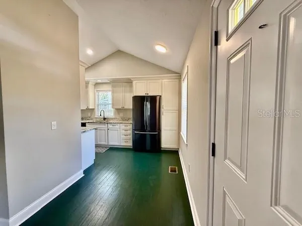 a view of a kitchen with a sink and a refrigerator