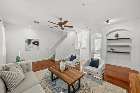 a living room with furniture a rug and a ceiling fan