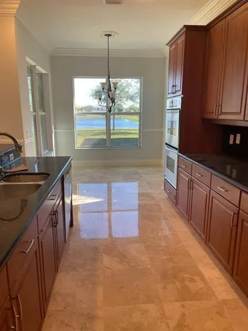 a kitchen with stainless steel appliances granite countertop a refrigerator a stove and a sink with wooden floor