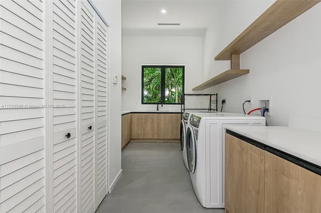 a utility room with cabinets washer and dryer