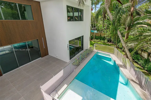 a view of a backyard with swimming pool and garden