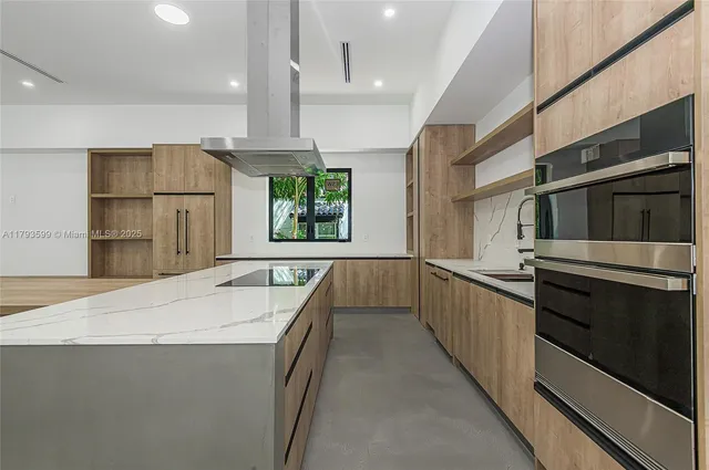a kitchen with stainless steel appliances granite countertop a sink and a stove top oven