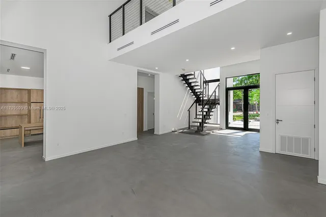 a view of a livingroom with wooden floor staircase and windows