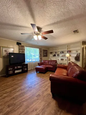 a living room with furniture a ceiling fan and a window