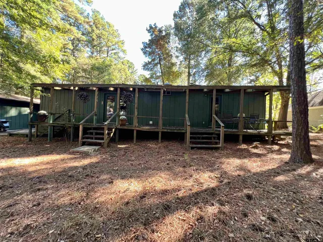 a view of a wooden chairs and table in a backyard