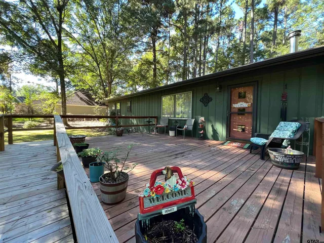 a view of patio with table and chairs barbeque with wooden floor and fence