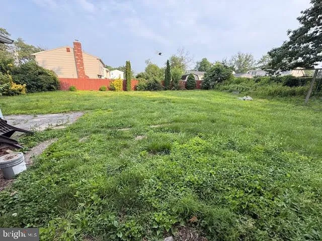 an aerial view of a residential houses with outdoor space and trees all around