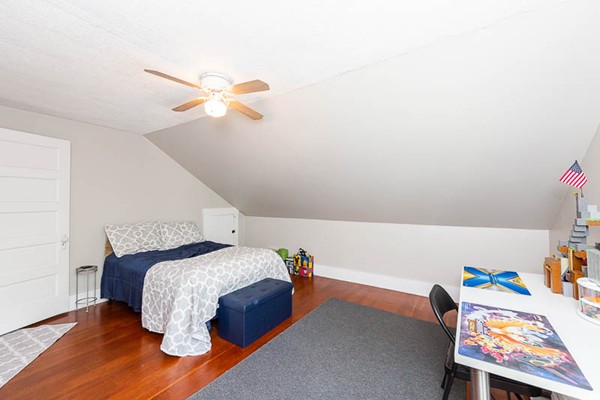 3 Spring Street Salisbury, MA 01952 - Photo 20 of 25 a bedroom with a bed and a chandelier