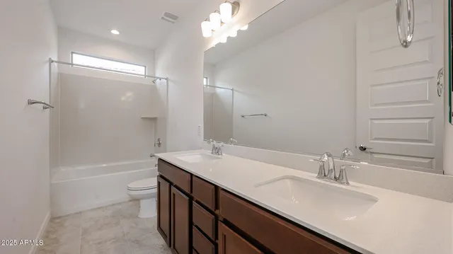 a bathroom with a sink a toilet a tub and a large mirror