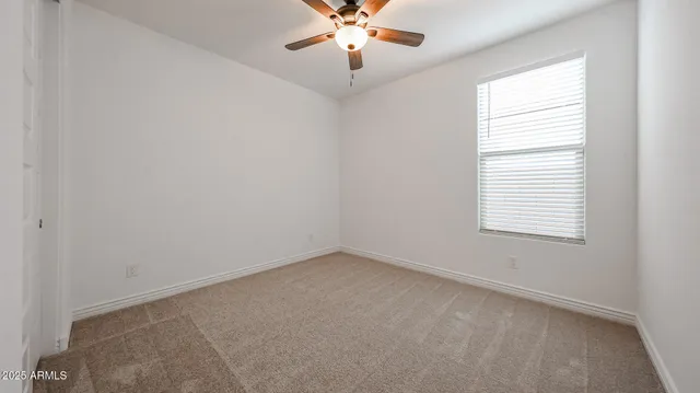 an empty room with window and chandelier fan