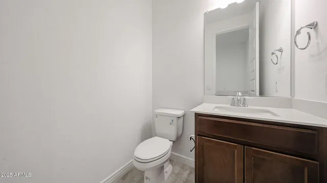 a bathroom with a granite countertop sink toilet and mirror