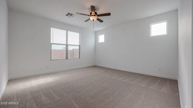an empty room with a window and a fan