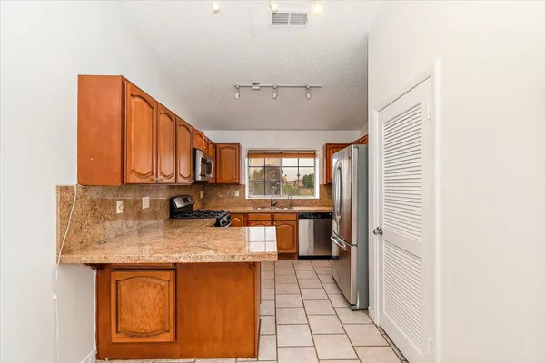 a kitchen with stainless steel appliances granite countertop a sink stove and cabinets