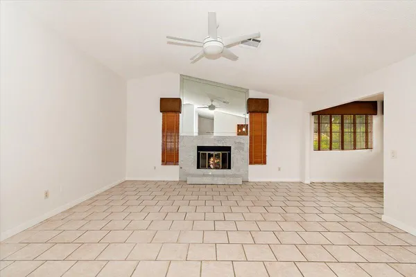 a view of an empty room with window and fireplace