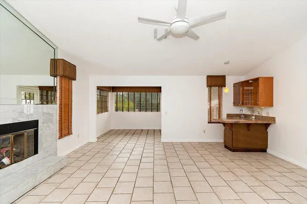 a view of a living room with a fireplace furniture and a ceiling fan