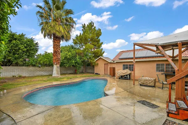 a view of a house with swimming pool and sitting area