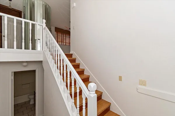 a view of staircase with railing and white walls