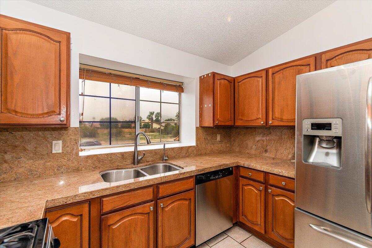 68954 Durango Road Cathedral City, CA 92234 - Photo 8 of 31 a kitchen with stainless steel appliances granite countertop a sink and a refrigerator