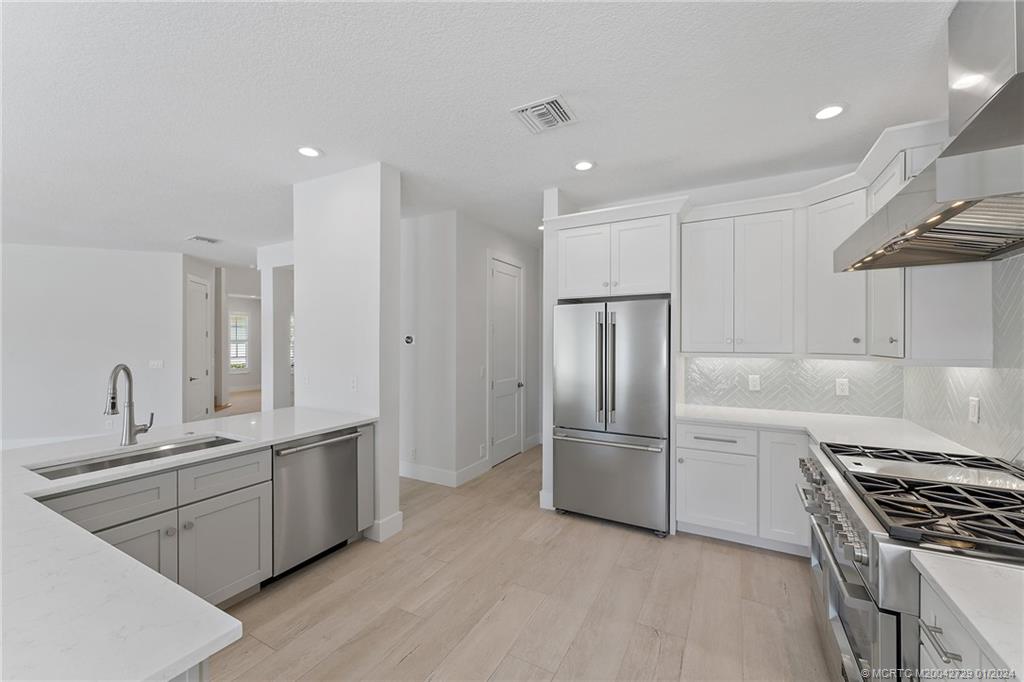 565 Southwest Yacht Basin Way Stuart, FL 34997 - Photo 14 of 55 a kitchen with stainless steel appliances a refrigerator sink and stove