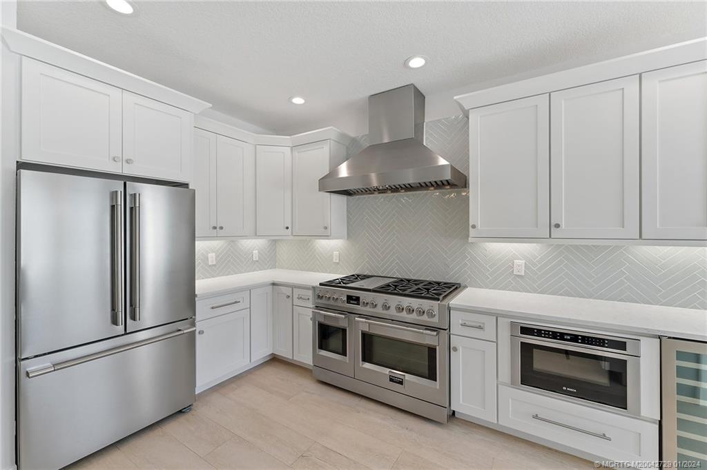 565 Southwest Yacht Basin Way Stuart, FL 34997 - Photo 15 of 55 a kitchen with stainless steel appliances a stove a refrigerator and cabinets