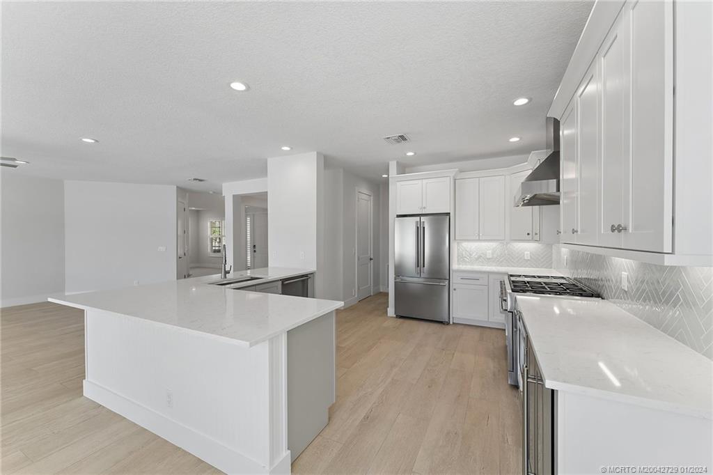 565 Southwest Yacht Basin Way Stuart, FL 34997 - Photo 16 of 55 a large kitchen with stainless steel appliances a large counter top a stove and a sink