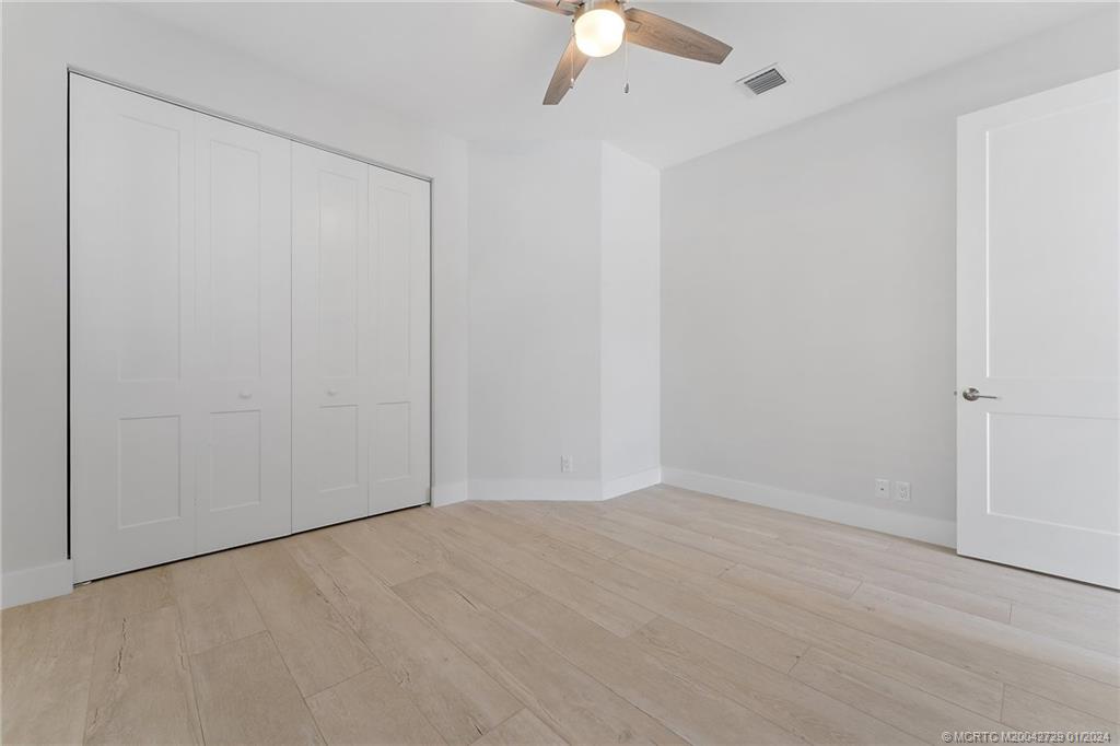 565 Southwest Yacht Basin Way Stuart, FL 34997 - Photo 19 of 55 an empty room with a ceiling fan and carpet