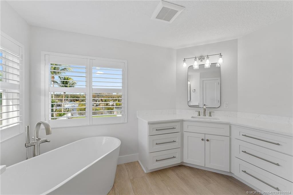 565 Southwest Yacht Basin Way Stuart, FL 34997 - Photo 29 of 55 a spacious bathroom with double vanity a window a bathtub and double vanity