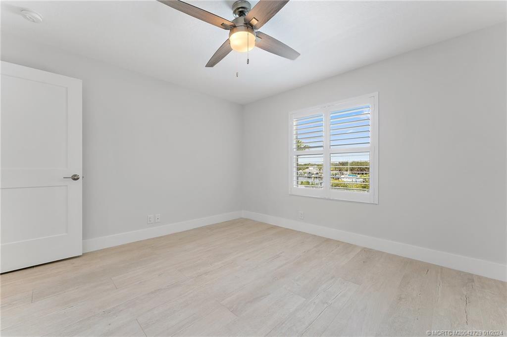 565 Southwest Yacht Basin Way Stuart, FL 34997 - Photo 34 of 55 an empty room with chandelier fan and windows