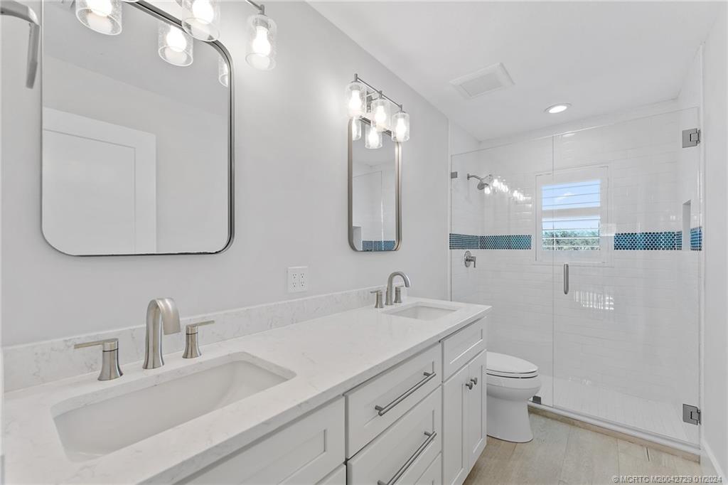 565 Southwest Yacht Basin Way Stuart, FL 34997 - Photo 35 of 55 a bathroom with a toilet sink and mirror