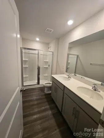 a bathroom with sink shower and mirror
