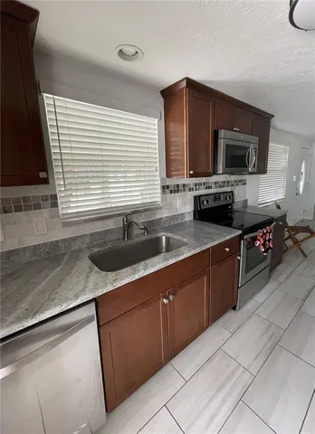a bathroom with a granite countertop toilet sink and mirror