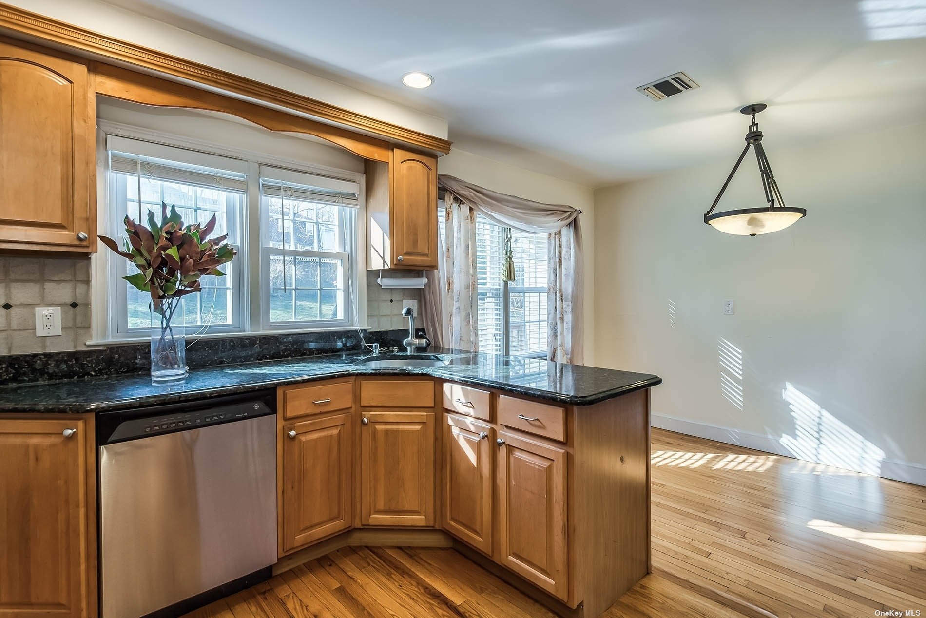 a kitchen with stainless steel appliances granite countertop a sink a window and counter space