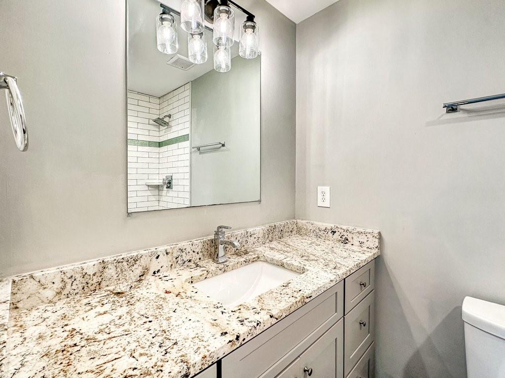 2350 Old Spring Road Smyrna, GA 30080 - Photo 15 of 26 a bathroom with a granite countertop sink a toilet and a mirror
