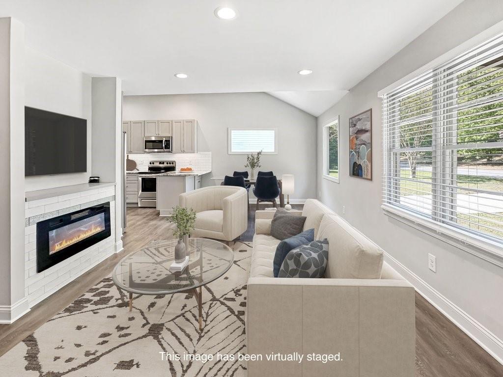 2350 Old Spring Road Smyrna, GA 30080 - Photo 8 of 26 a living room with furniture a flat screen tv and a fireplace