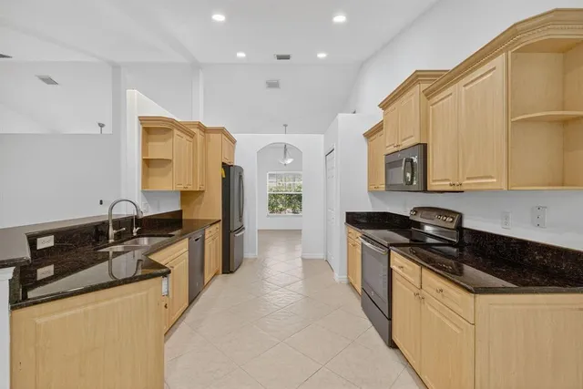 a kitchen with stainless steel appliances granite countertop a sink stove and cabinets