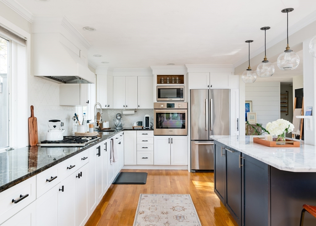 255 Elm Street Marshfield, MA 02050 - Photo 15 of 42 a kitchen with stainless steel appliances kitchen island granite countertop a sink and cabinets