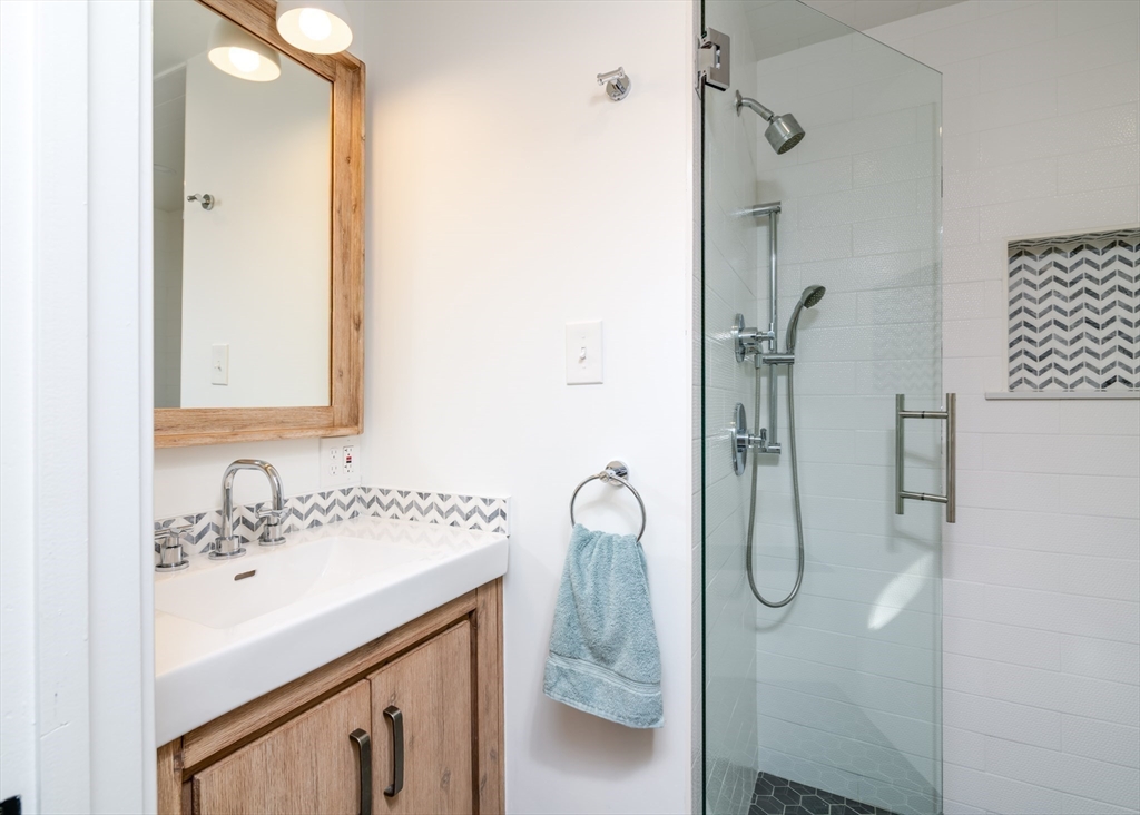 255 Elm Street Marshfield, MA 02050 - Photo 24 of 42 a bathroom with a sink a vanity a mirror and shower