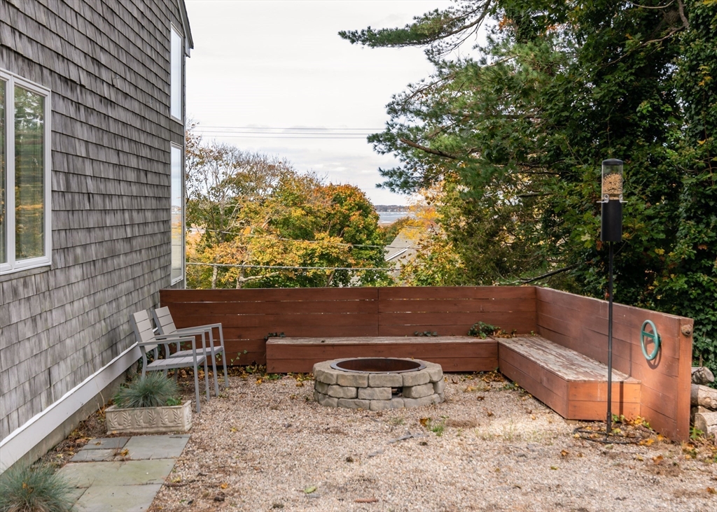 255 Elm Street Marshfield, MA 02050 - Photo 32 of 42 a backyard of a house with wooden fence and large trees