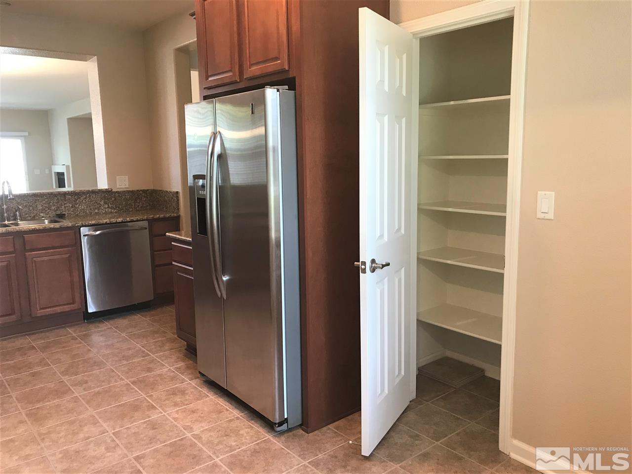 565 Little Sorrel Court Reno, NV 89521 - Photo 3 of 25 a view of a kitchen with a refrigerator and cabinets