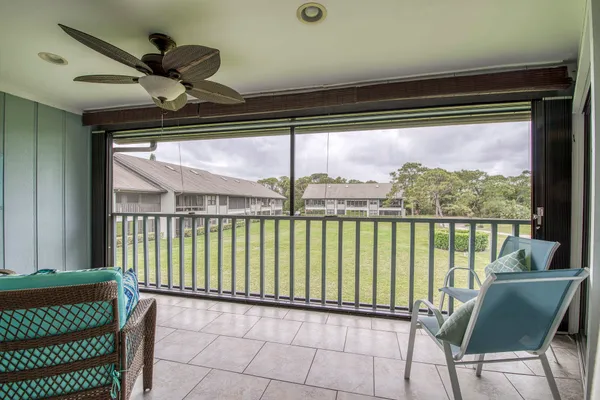 a view of a porch with furniture and a floor to ceiling window