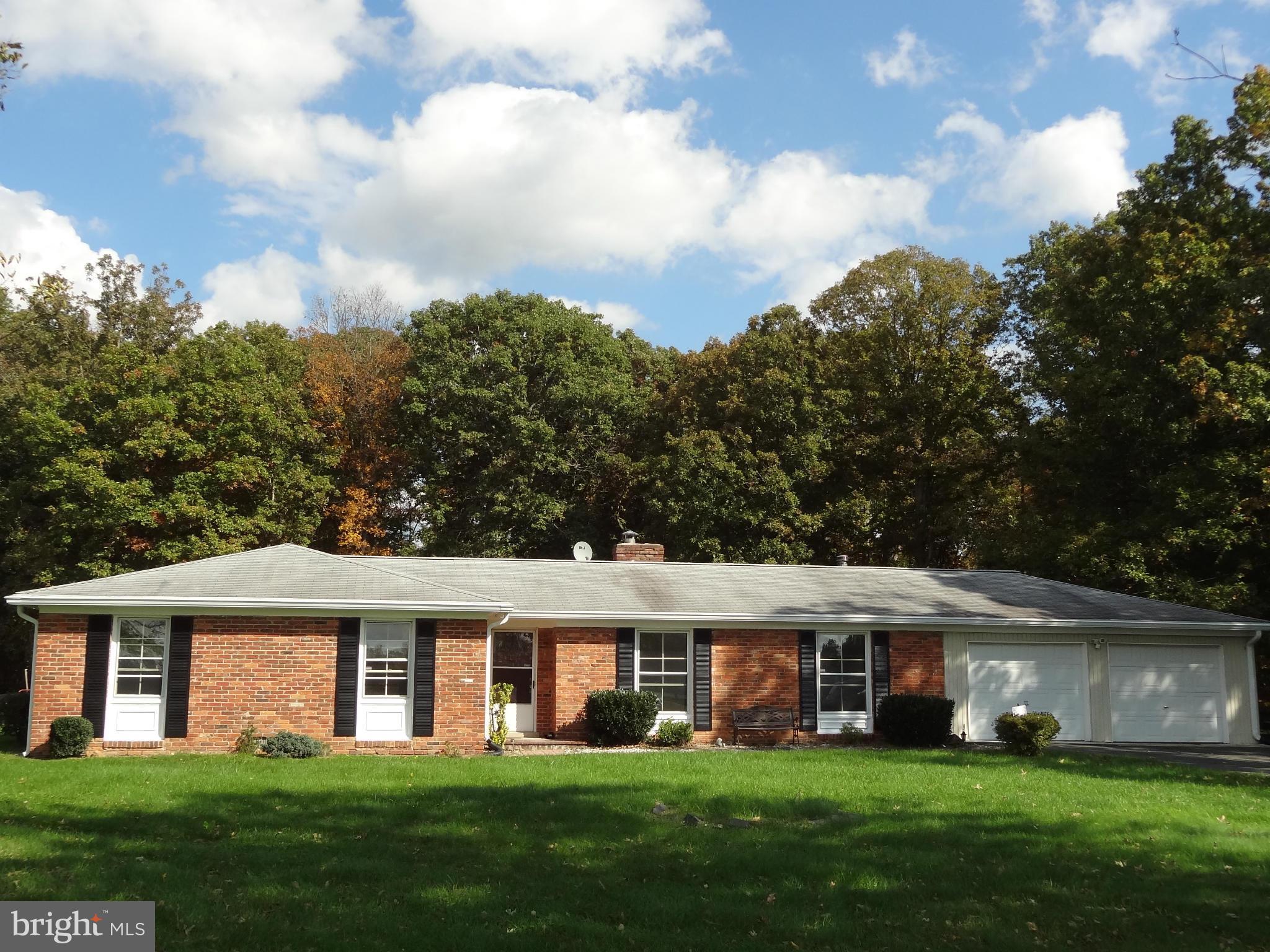 4878 Dumfries Road Catlett, VA 20119 - Photo 1 of 30 a front view of a house with a garden and trees