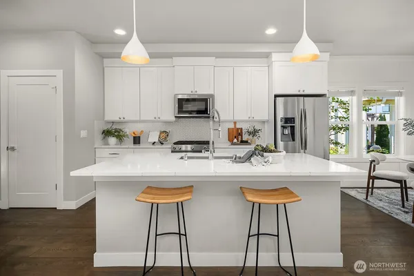 a kitchen with stainless steel appliances granite countertop a stove a sink a microwave a center island and a refrigerator