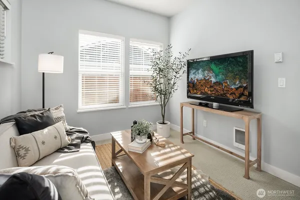 a living room with furniture a flat screen tv and a window