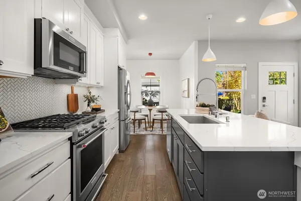 a kitchen with stainless steel appliances granite countertop a sink stove and microwave