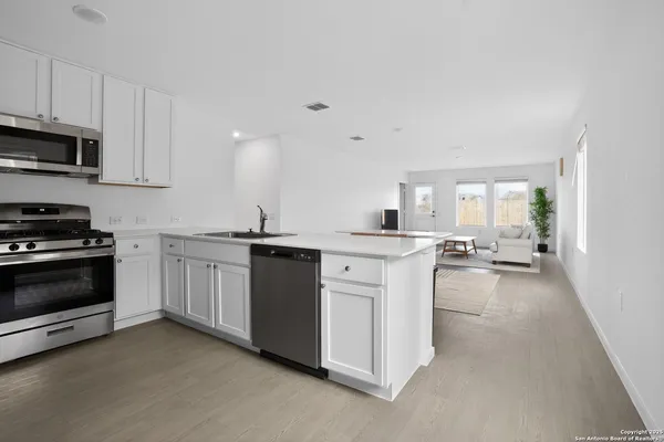 a kitchen with appliances a sink and cabinets