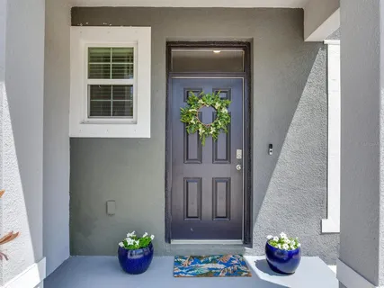 a hallway with painting on the wall and a potted plant