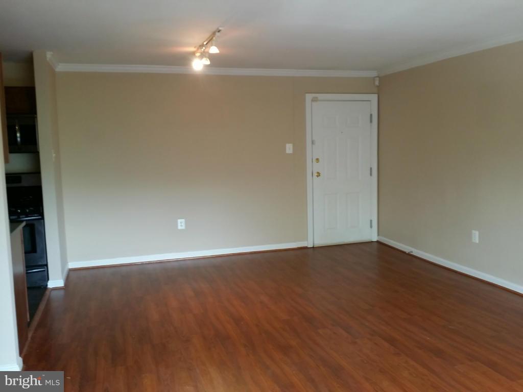 3105 Naylor Road Southeast, Unit 303 Washington, DC 20020 - Photo 2 of 10 an empty room with wooden floor and windows